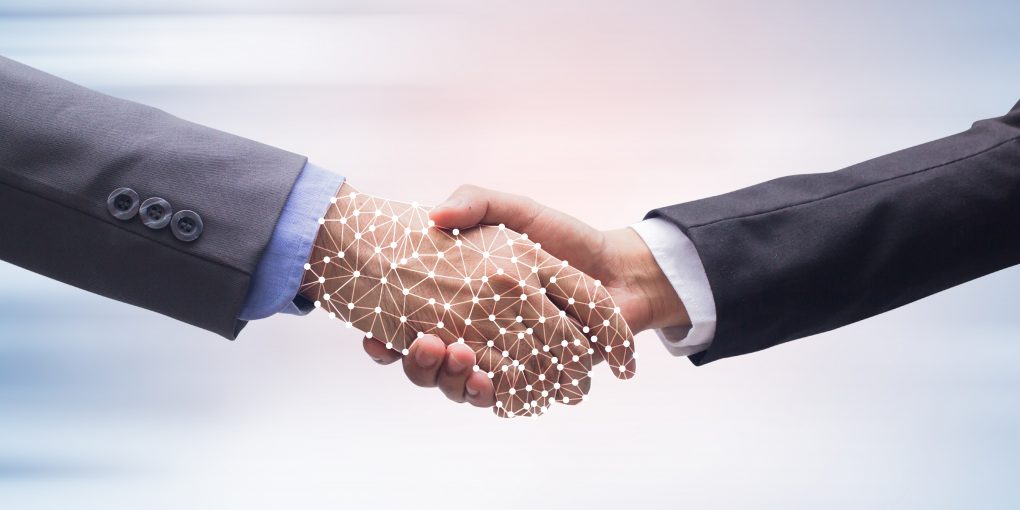 Two businesspeople shaking hands, one of them outlined in lines and dots