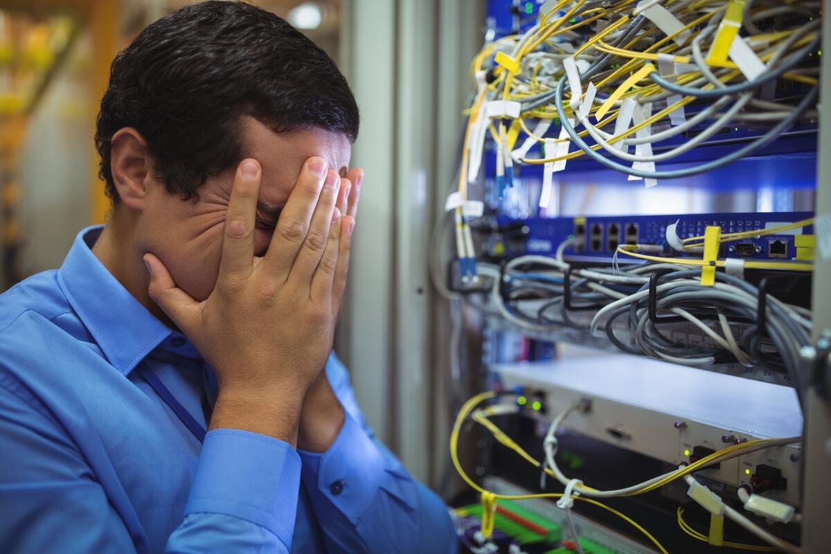 Technician getting stressed over server maintenance in server room