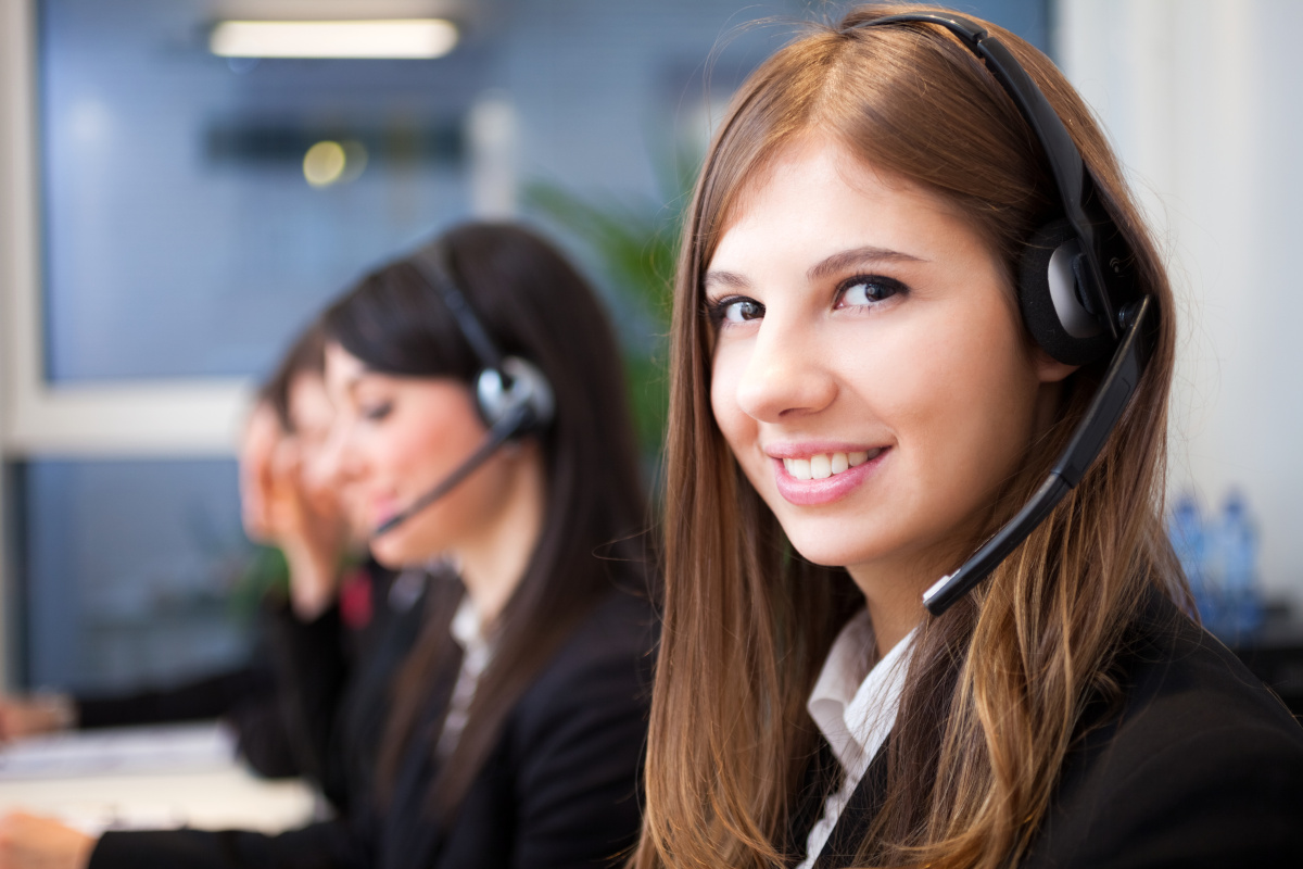 A smiling employee with a work phone headset