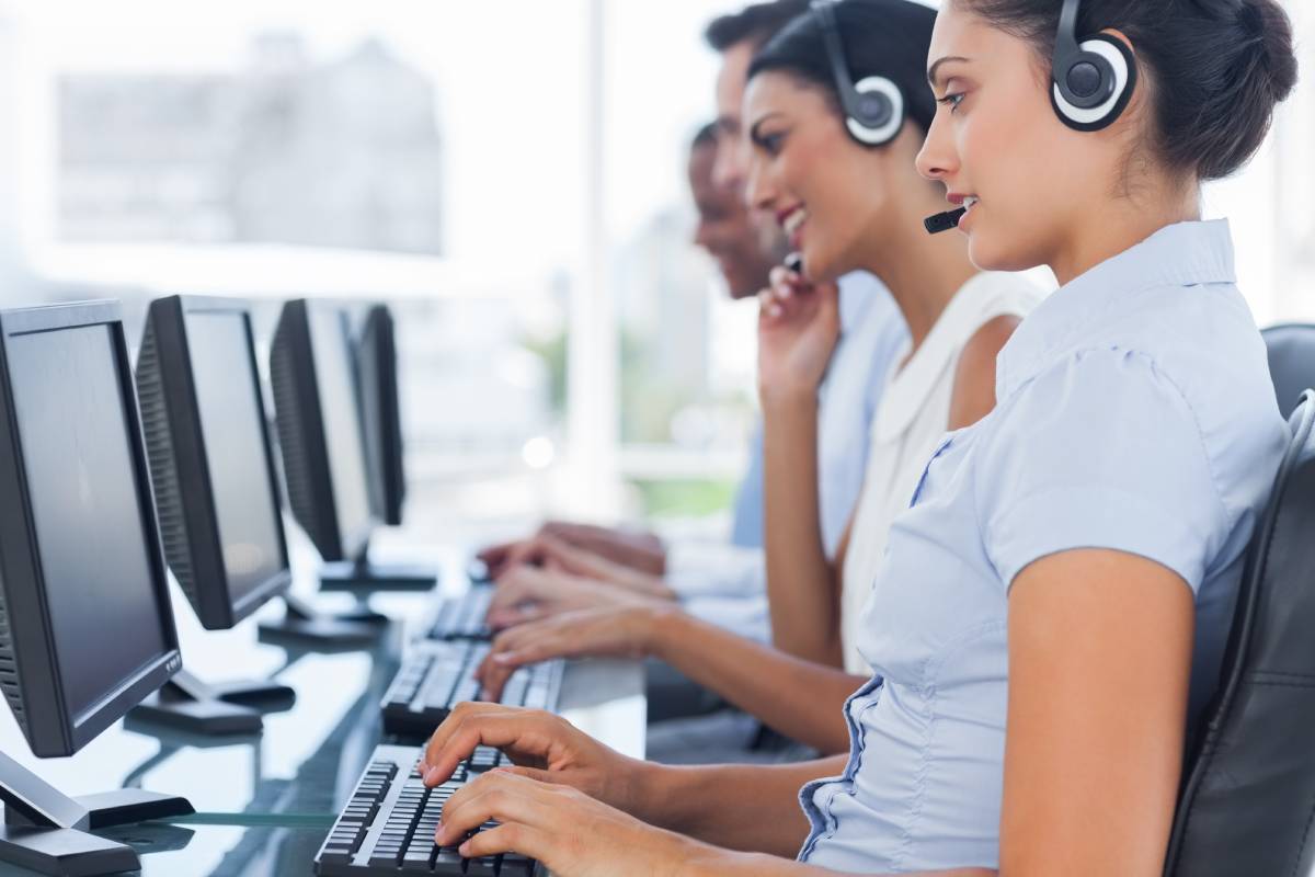 Employees wearing headsets answering questions while working at a Call Center or Help Desk
