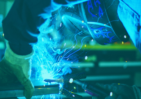 Green-hued view of a welder using a blowtorch
